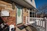 View of exterior entry featuring brick siding and stone siding