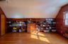 Office space with vaulted ceiling, radiator heating unit, wooden walls, and wood finished floors