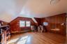 Bonus room featuring radiator heating unit, vaulted ceiling, wood walls, and wood finished floors