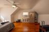 Bedroom with vaulted ceiling, wood finished floors, cooling unit, and ceiling fan