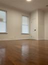 Empty room with dark wood-type flooring, baseboards, and a smoke detector