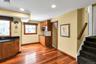 Kitchen featuring wood finish cabinets, light wood-style flooring, decorative backsplash, and dark stone countertops