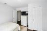 Bedroom with dark wood finished floors and baseboards