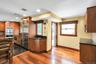 Kitchen with decorative backsplash, wood finish cabinets, stainless steel appliances, dark wood-type flooring, and recessed lighting