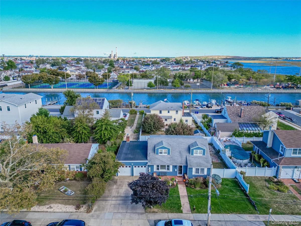 Aerial perspective of suburban area featuring a large body of water and a notable bridge