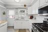 Kitchen featuring appliances with stainless steel finishes, tasteful backsplash, white cabinetry, ornamental molding, and open shelves