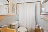 Bathroom with tile walls, crown molding, and shower / tub combo with curtain