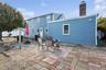 Back of house featuring a patio, a chimney, and an outdoor fire pit