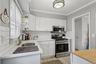 Kitchen with appliances with stainless steel finishes, white cabinetry, backsplash, ornamental molding, and open shelves