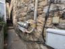 Exterior view of stone siding and some of the electric meters of the building.