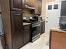 Kitchen featuring appliances with stainless steel finishes, backsplash, light stone countertops, and under cabinet range hood