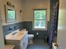 Full bath featuring vanity, tile walls, plenty of natural light, dark tile patterned floors, and shower / tub combo with curtain