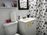 Full bath featuring vanity and tile walls