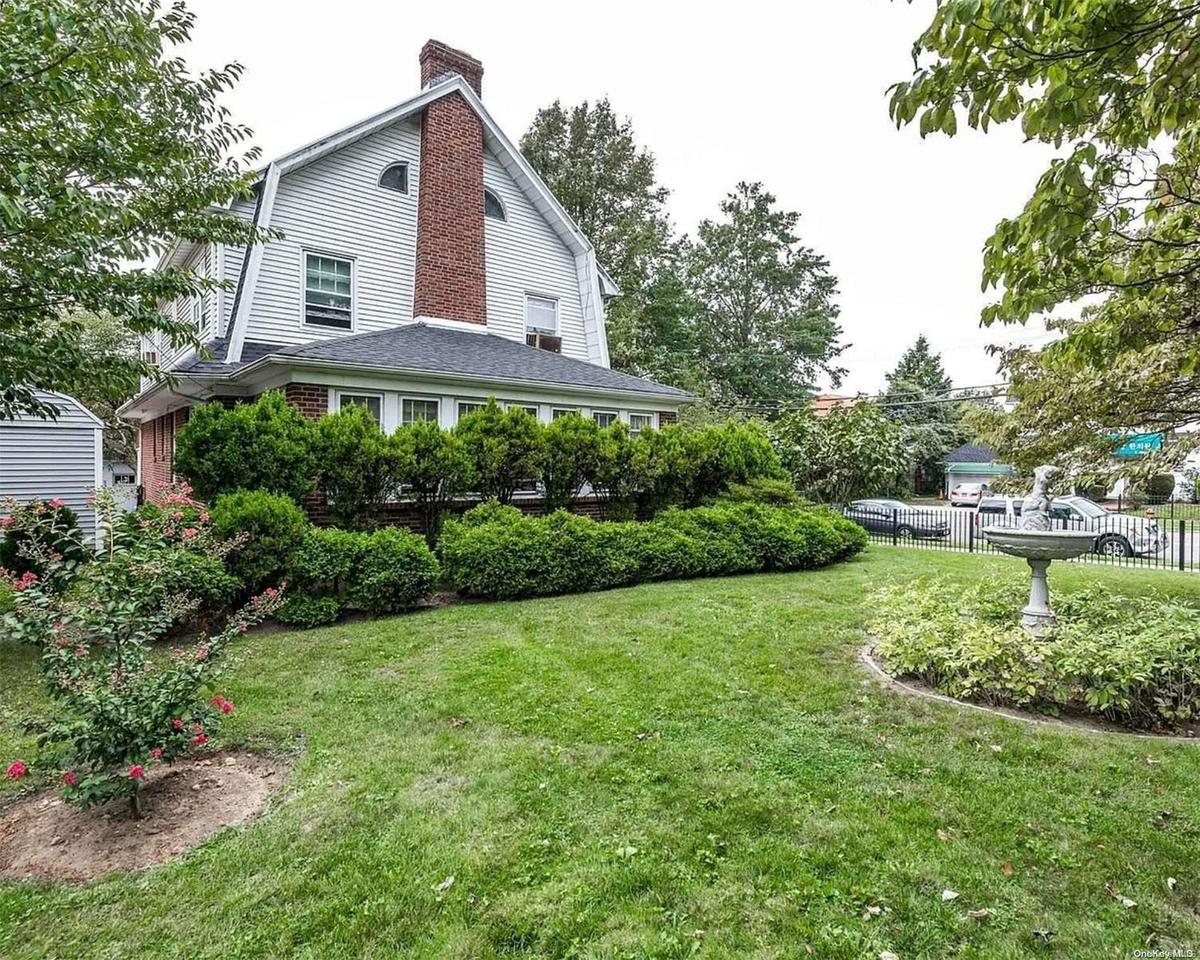 The expansive, fenced-in yard features lovely gardens
