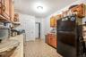 Kitchen featuring stainless steel range with gas cooktop and black fridge
