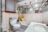 Full bathroom with toilet, tile patterned floors, and tile walls