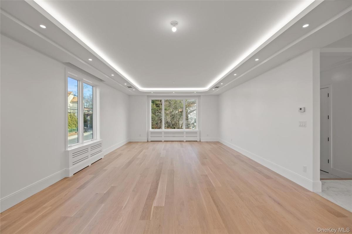 Oversized dining room/ living room featuring LED tray ceilings