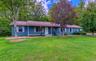 Ranch-style house with covered porch, a front yard, and roof with shingles
