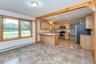 Kitchen with stainless steel appliances, baseboard heating, a peninsula, light countertops, and recessed lighting