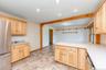 Kitchen with appliances with stainless steel finishes, light brown cabinetry, light countertops, a peninsula, and recessed lighting