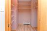 Spacious closet with a baseboard heating unit and wood finished floors