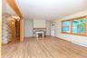 Unfurnished living room with light wood-type flooring, baseboards, and a baseboard heating unit
