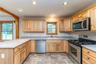 Kitchen featuring appliances with stainless steel finishes, a sink, a peninsula, recessed lighting, and stone finish flooring