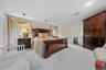 Bedroom featuring light colored carpet, a textured ceiling, and a baseboard heating unit