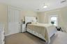 Bedroom featuring light carpet and baseboards