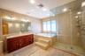 Bathroom featuring tile walls, a garden tub, double vanity, light tile patterned flooring, and a stall shower