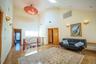 Living room with high vaulted ceiling, radiator, and a skylight