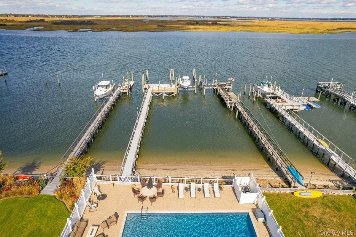 Aerial view of a pool area and a large body of water