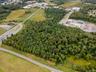 Aerial view of property and surrounding area featuring a tree filled landscape