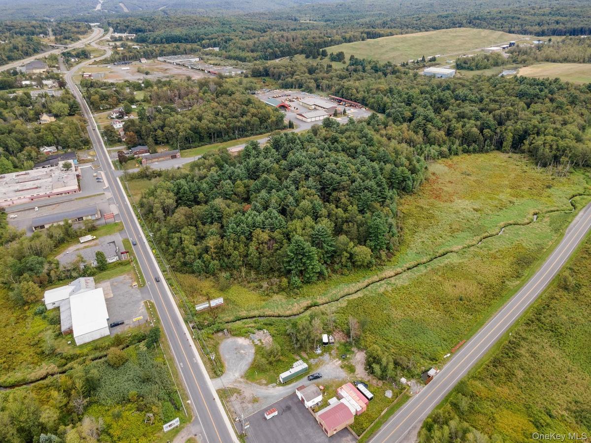 Aerial view of property and surrounding area with a heavily wooded area