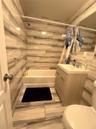 Bathroom featuring vanity, shower / bath combo with shower curtain, and tile walls