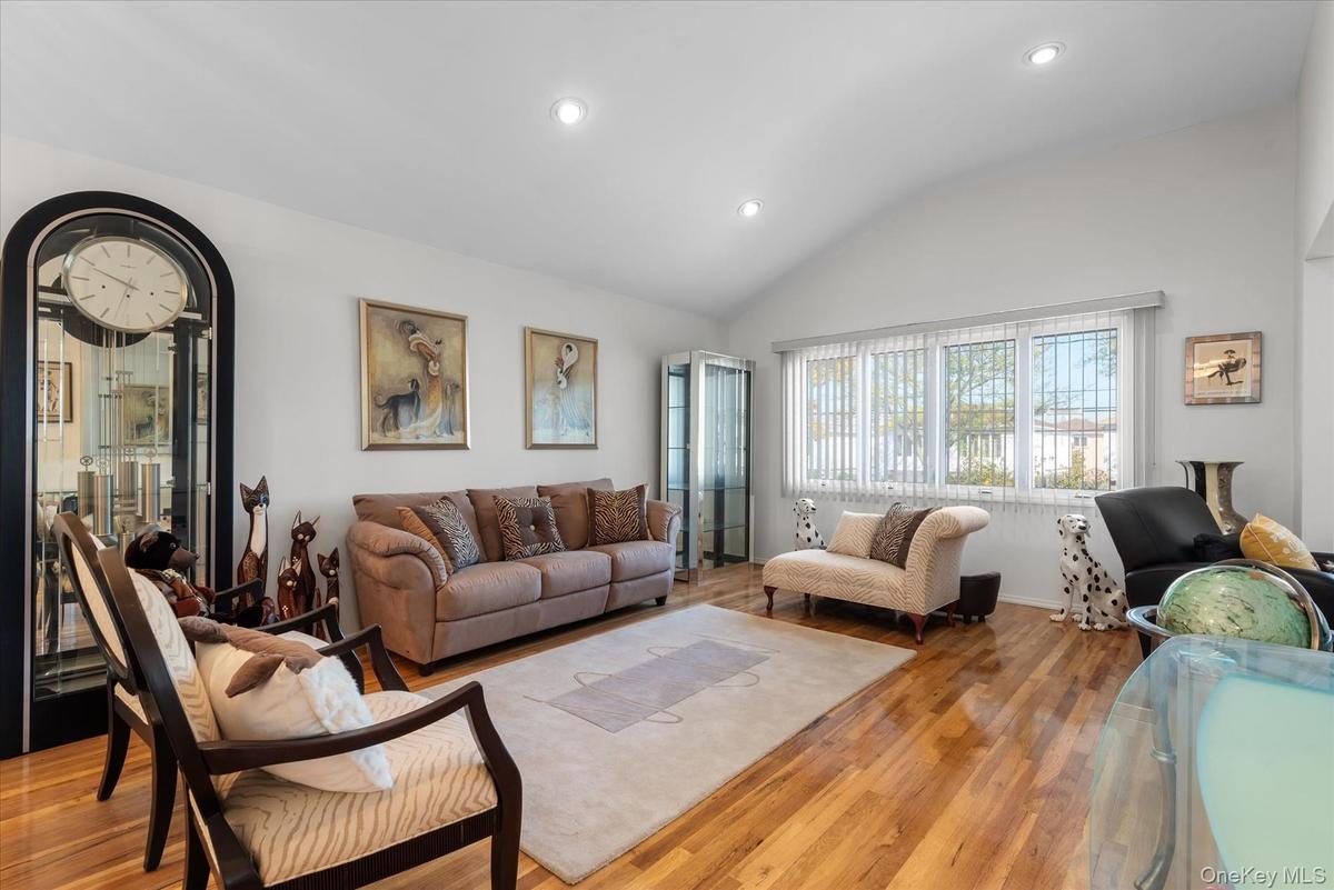 Living room featuring vaulted ceiling and light hardwood / wood-style flooring