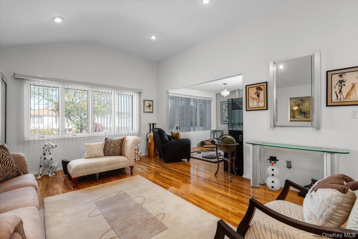 Living room with wood-type flooring and vaulted ceiling