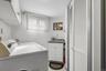 Clothes washing area with cabinets, light tile patterned floors, sink, and washing machine and clothes dryer