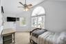 Bedroom featuring light colored carpet, lofted ceiling, and a ceiling fan