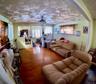 Living area with wood finished floors, radiator heating unit, and hanging lights