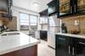 Kitchen featuring dark cabinets, backsplash, and freestanding refrigerator