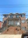 Traditional home featuring stairway, brick siding, and a balcony