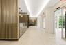 Hall featuring light tile patterned flooring and a raised ceiling
