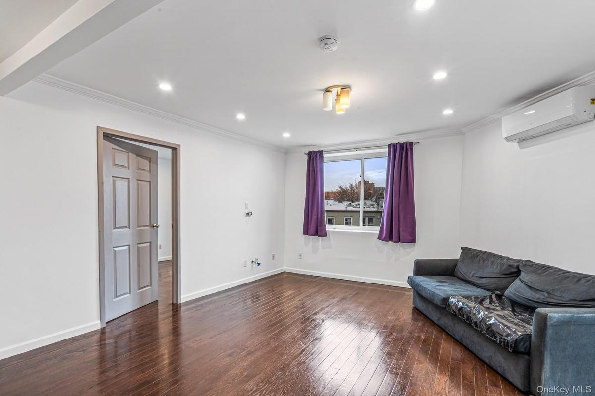 Unfurnished room featuring dark wood-type flooring, ornamental molding, a wall mounted air conditioner, and recessed lighting