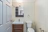 Half bathroom with vanity and tile walls