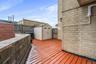 Wooden terrace featuring a fenced backyard and a storage unit