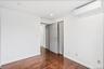 Empty room featuring an AC wall unit, dark wood finished floors, and recessed lighting