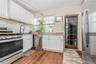 Kitchen with stainless steel appliances, white  shaker style cabinets, and light wood-style floors