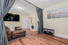 Living room with wood finished floors, a glass covered fireplace, and radiator heating unit