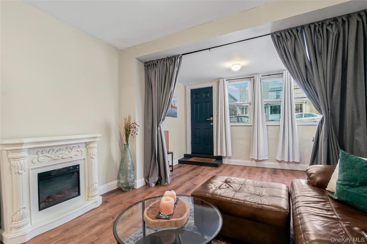 Living room featuring wood finished floors and a glass covered fireplace